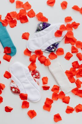 Hygienic Pads and Flowers Petals on White Background